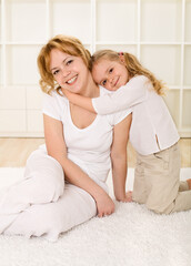 Woman and little girl sharing a tender moment hugging and smiling