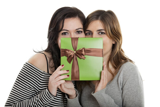 Two beautiful young womenÕs holding a present