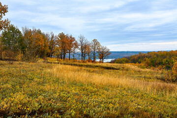 Autumn in the mountains on a sunny warm day with a river and blue sky.