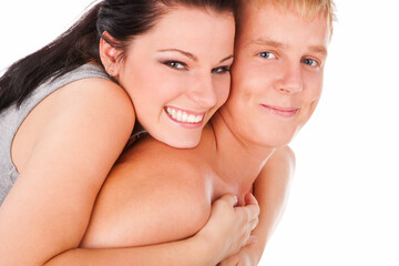 Obraz na płótnie Canvas Happy teens couple cuddling over isolated white