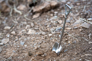 metal shovel in the ground on brown soil