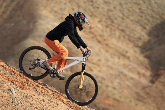 Girl downhill on mountain bike in red canyon