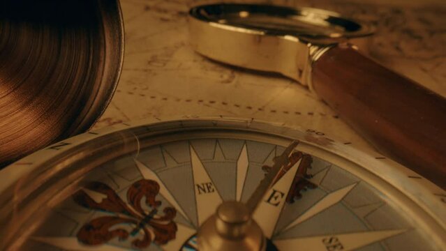 Compass and magnifier on a old vintage world map with countries and continents. Retro style. Concept of geography or global history and cartography. Wars of conquest and navigation. 4K ProRes