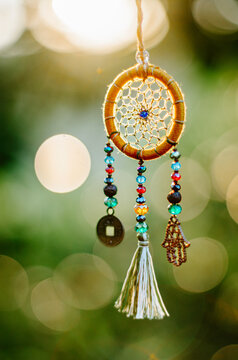 Close up of dreamcatcher necklace with sacred geometry circle with bokeh background