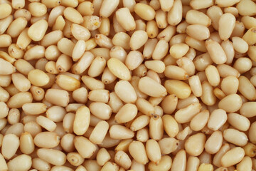 A pile of raw shelled pine nuts arranged randomly. View from above. Closeup