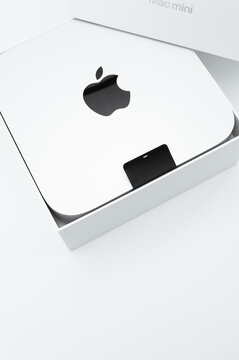 immagine primo piano editoriale illustrativa di scatola imballaggio aperta  di computer Mac mini M2 di Apple su superficie di lavoro bianca