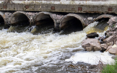 A concrete pipe that carries smelly, polluted sewage into the river through pipes. Pollution of the...