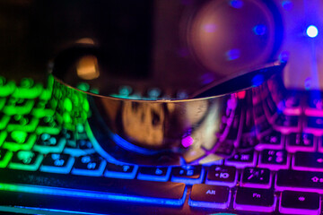 Fototapeta na wymiar Dark futuristic glasses lie on a multi-colored keyboard close-up 