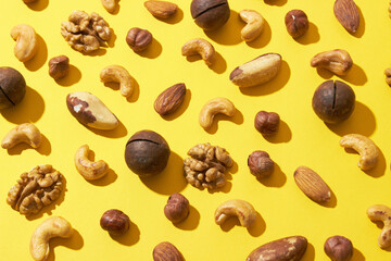 Pattern of nuts mix on yellow background