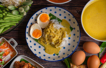 Rice noodles with fish curry sauce and spicy curry sauce, southern style with vegetables set, fried chicken, boiled egg and pickled vegetables, Thai traditional style. (Kanom Jeen Nam Ya)