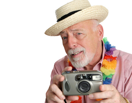 A curious senior man using his camera on vacation.