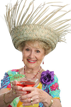 A beautiful senior lady on vacation making a toast with her tropical cocktail.  Isolated