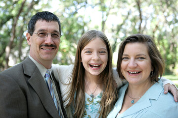 A happy family laughing together.  Focus on mom & daughter.