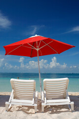 Sun loungers and parasol on an empty tropical beach