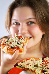 Beautiful no make-up girl eating a piece of Pizza