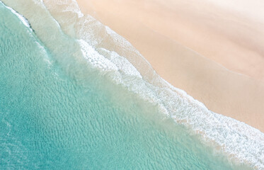 Fototapeta na wymiar Aerial view of a beach with nice waves and shades of blues. Beautiful beach and scenes