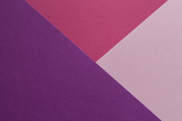 Pink, burgundy and purple paper lie on the table in a geometric composition