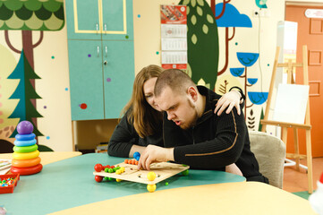 a mother woman is engaged with an autistic son