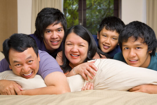 Asian family smiling on the bed happily