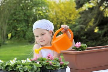 Young girl watering flowers