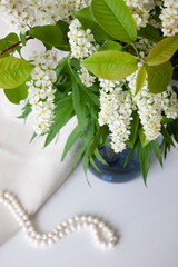 Spring flowers in blue vase and pearl beads. Selective focus