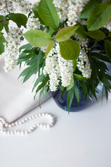 Spring flowers in blue vase and pearl beads. Selective focus