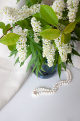 Spring flowers in blue vase and pearl beads. Selective focus