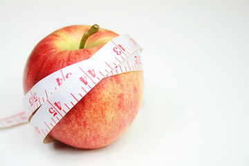 Measurement tape wrapped around red apple - health, diet