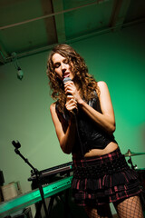 Fototapeta na wymiar Caucasian female singning into microphone.
