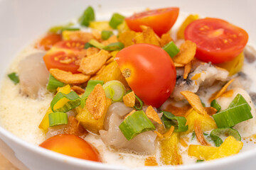 Close-up view of sop kaki kambing or mutton soup, a traditional food from Betawi-Jakarta, Indonesia. Made from mutton or lamb, spices, coconut milk, and milk. Isolated on white background.