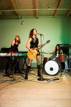 Girl band playing their instruments.