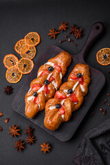 Delicious fresh crispy pastry in the form of a pigtail with strawberries and blueberries