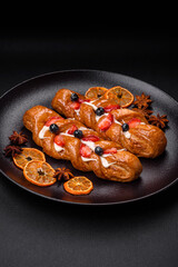 Delicious fresh crispy pastry in the form of a pigtail with strawberries and blueberries