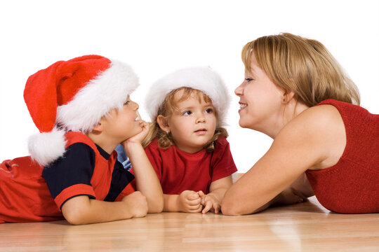 Woman telling a christmas story to her kids laying on the floor - isolated