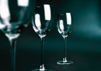 Three empty glasses on dark green  background