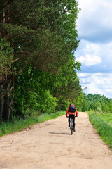 Obraz premium Traveling cyclists on dirt road