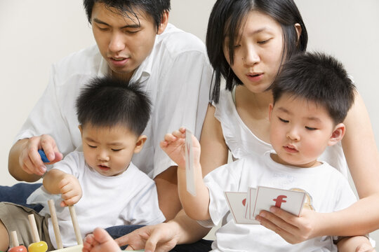 Young Asian family spending time together, teaching and playing together with their sons