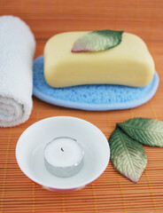 Obraz na płótnie Canvas Spa products including soap and a candle - health and beauty