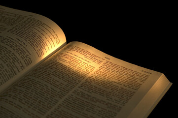 Closeup of a part of the Bible. On dark background.