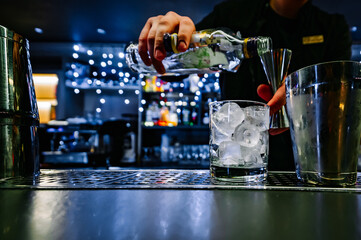 man bartender hand making negroni cocktail. Negroni classic cocktail and gin short drink with sweet vermouth, red bitter liqueur