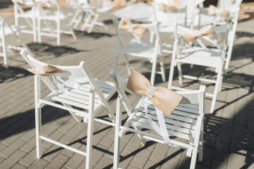 Photo details on the veil. Many white chairs are decorated with stylish soft pink bows. wedding...