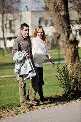 Fototapeta premium happy young married family couple outdoor in nature have fun and waiting baby and representing young family growth and pregnancy concept