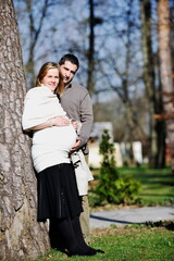 Fototapeta premium happy young married family couple outdoor in nature have fun and waiting baby and representing young family growth and pregnancy concept