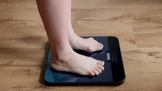 woman stepping on body scale being shocked with weight.female with fat on belly and vegetables in plate.after childbirth recovery,get slim fit,diet concept.measure tape on neck,hands on face