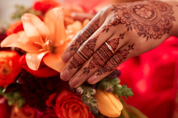 Henna, hand and Indian bride at her wedding event with flowers or bouquet for decoration or design....