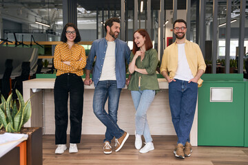 Obraz premium Group of smiling business people, colleagues, creative coworkers looking at camera in modern office. Happy student standing together in university campus, education