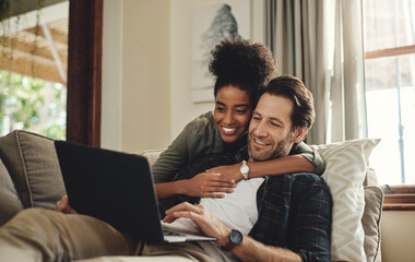 Laptop, streaming and an interracial couple watching a movie using an online subscription service for entertainment. Computer, relax or internet with a man and woman bonding together over a video