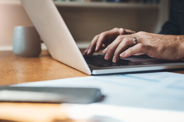 Hands, closeup and man with laptop in home office for finance, review or budget planning. Fingers, keyboard and male person paying bills online for savings, investment and mortgage or startup loan