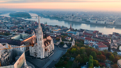 Budapest, Hungary, flying over the famous Fishermans Bastion and Matthias church towards the River Danube with Parliament of Hungary at background