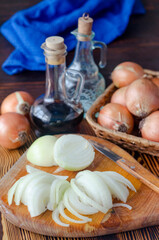 onion cut into half rings on a kitchen board